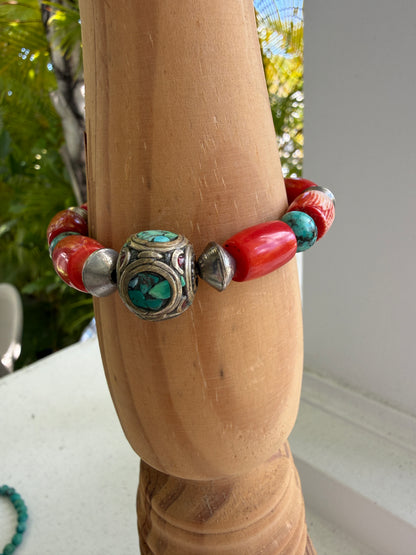 Old Tibetan bead with turquoise inlay surrounded by coral and turquoise beads stretch bracelet. 7”