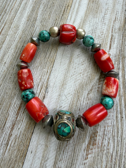 Old Tibetan bead with turquoise inlay surrounded by coral and turquoise beads stretch bracelet. 7”