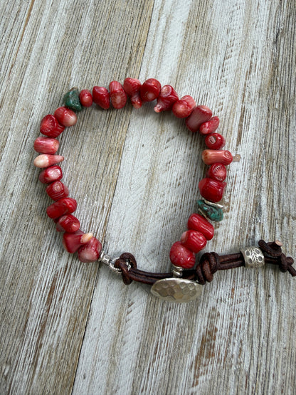 Coral beads connected by a fine silver hammered button and leather loop. 6.5”
