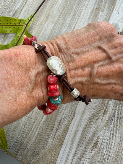 Coral beads connected by a fine silver hammered button and leather loop. 6.5”