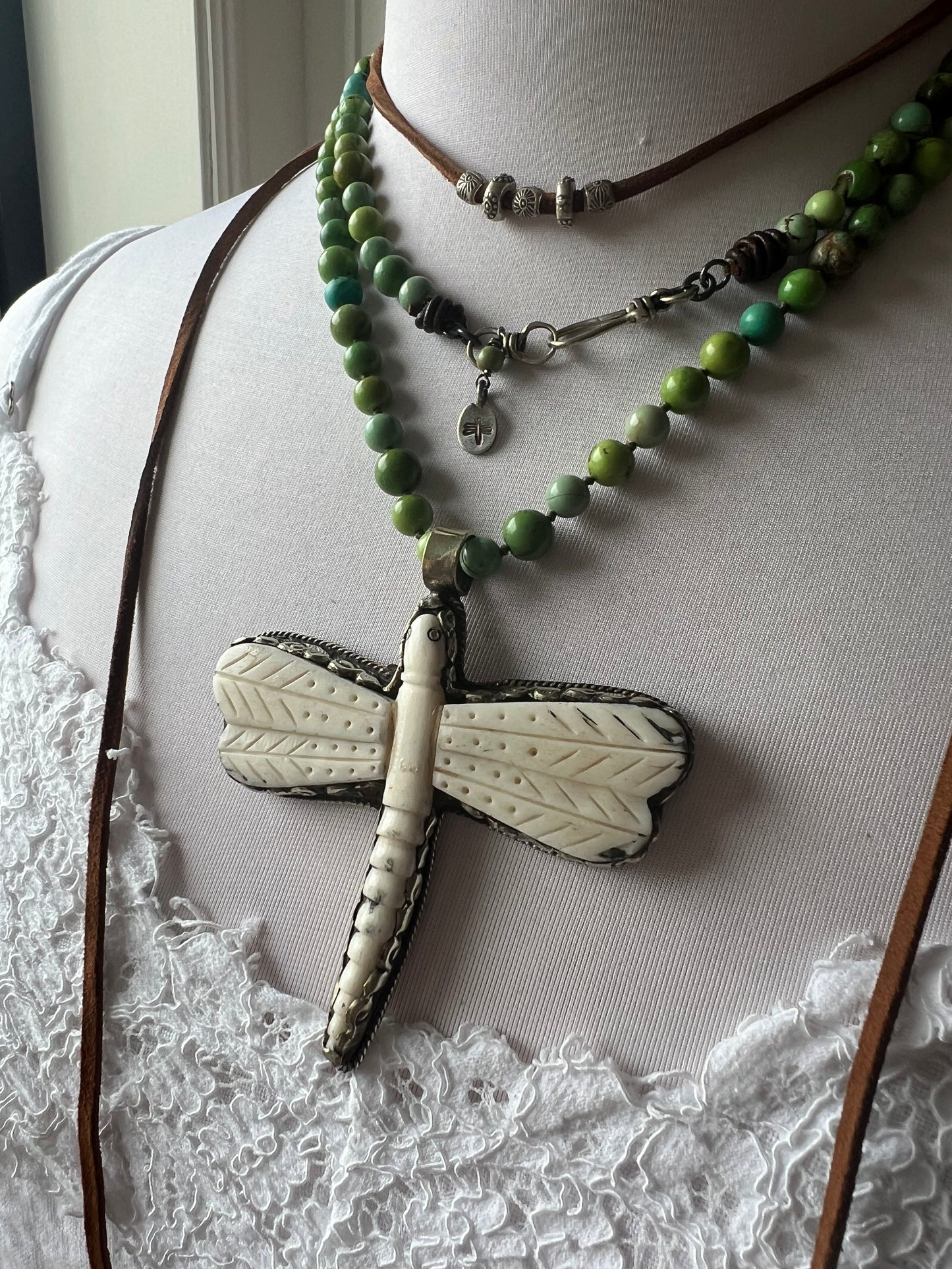 Tibetan carved bone dragonfly pendant on green and blue turquoise. Long, knotted necklace.