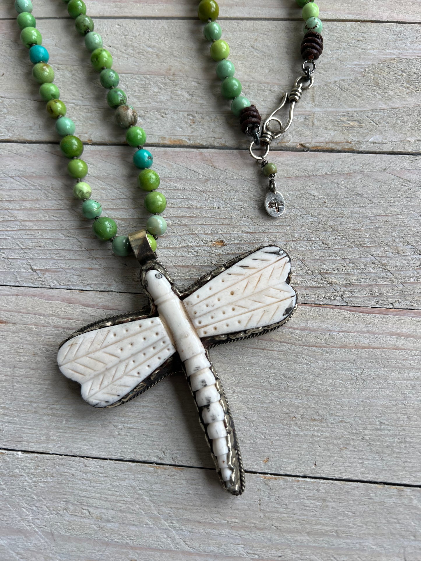 Tibetan carved bone dragonfly pendant on green and blue turquoise. Long, knotted necklace.