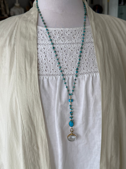 Turquoise rosary style chain with turquoise and gold accent pieces and brass locket necklace.