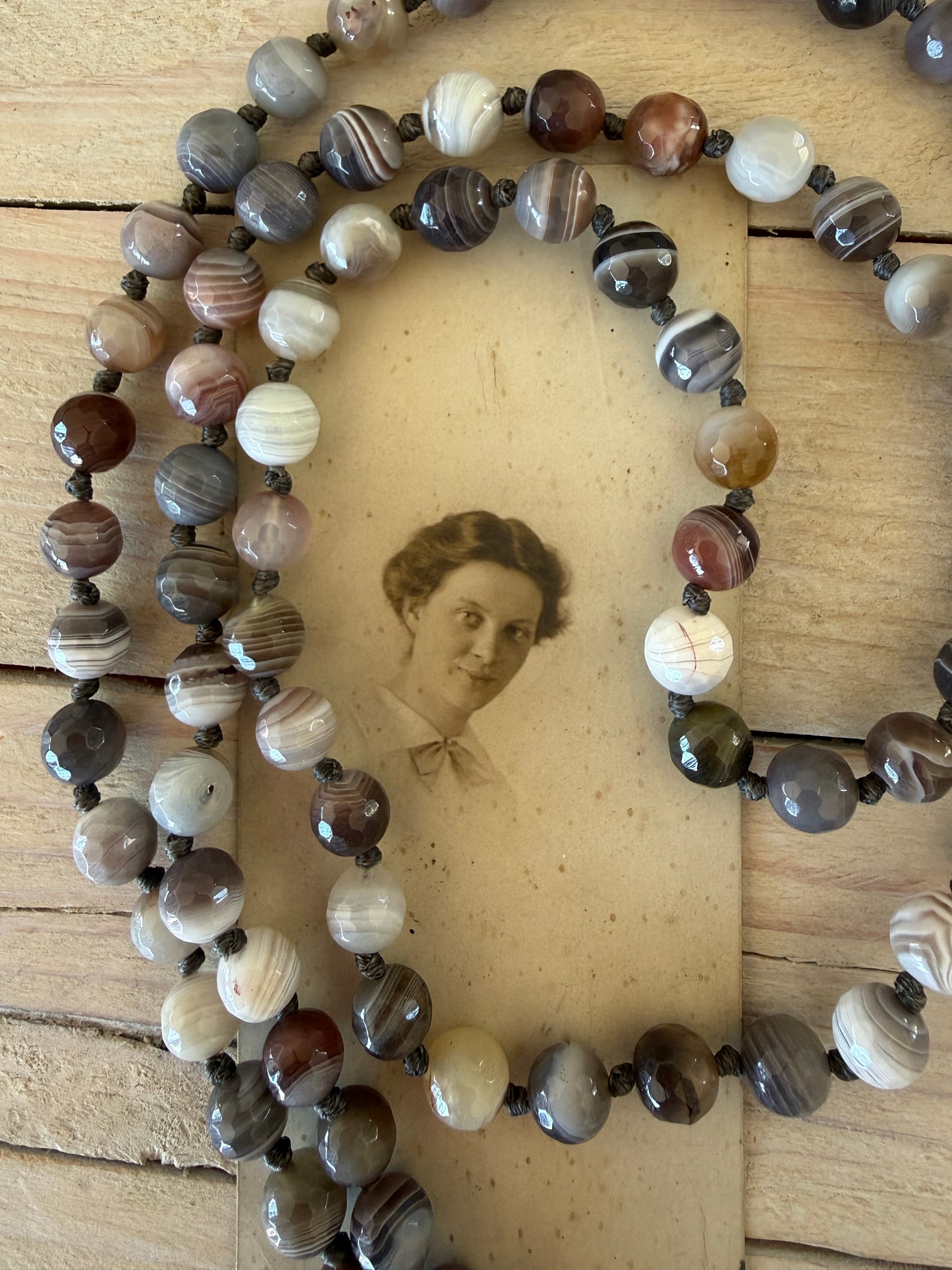 Carved Tibetan Mother of Pearl cross on knotted, faceted Botswana agates necklace.
