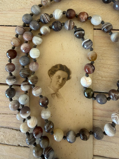 Carved Tibetan Mother of Pearl cross on knotted, faceted Botswana agates necklace.
