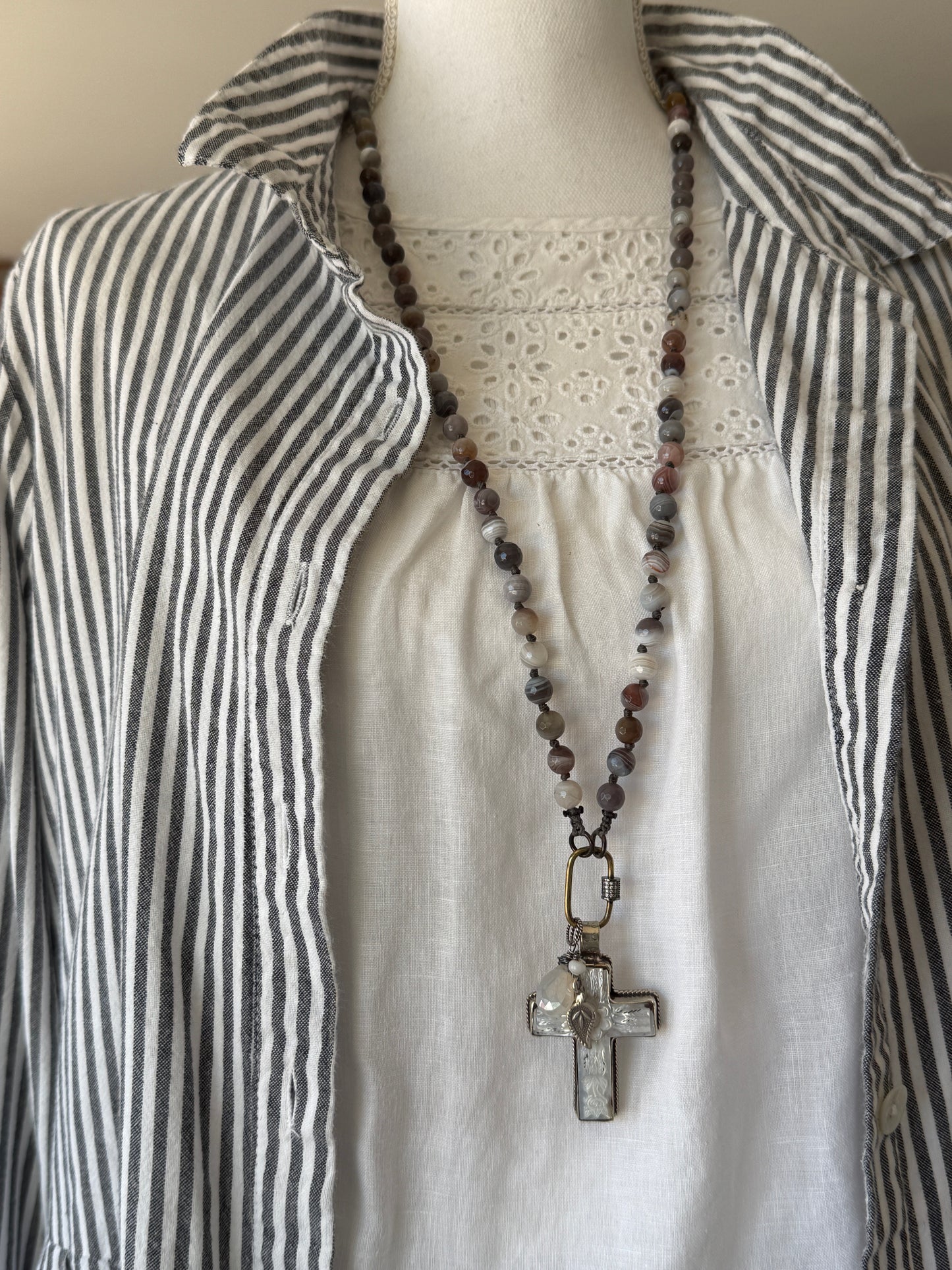 Carved Tibetan Mother of Pearl cross on knotted, faceted Botswana agates necklace.