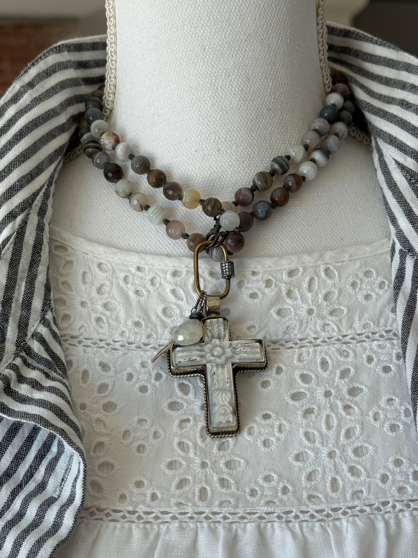 Carved Tibetan Mother of Pearl cross on knotted, faceted Botswana agates necklace.