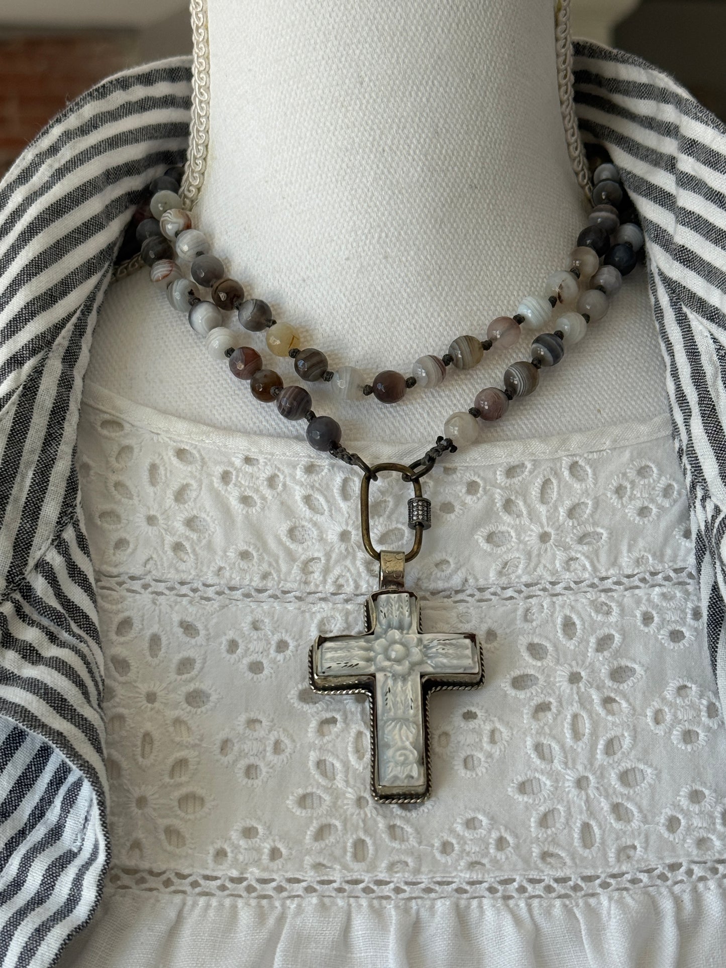 Carved Tibetan Mother of Pearl cross on knotted, faceted Botswana agates necklace.
