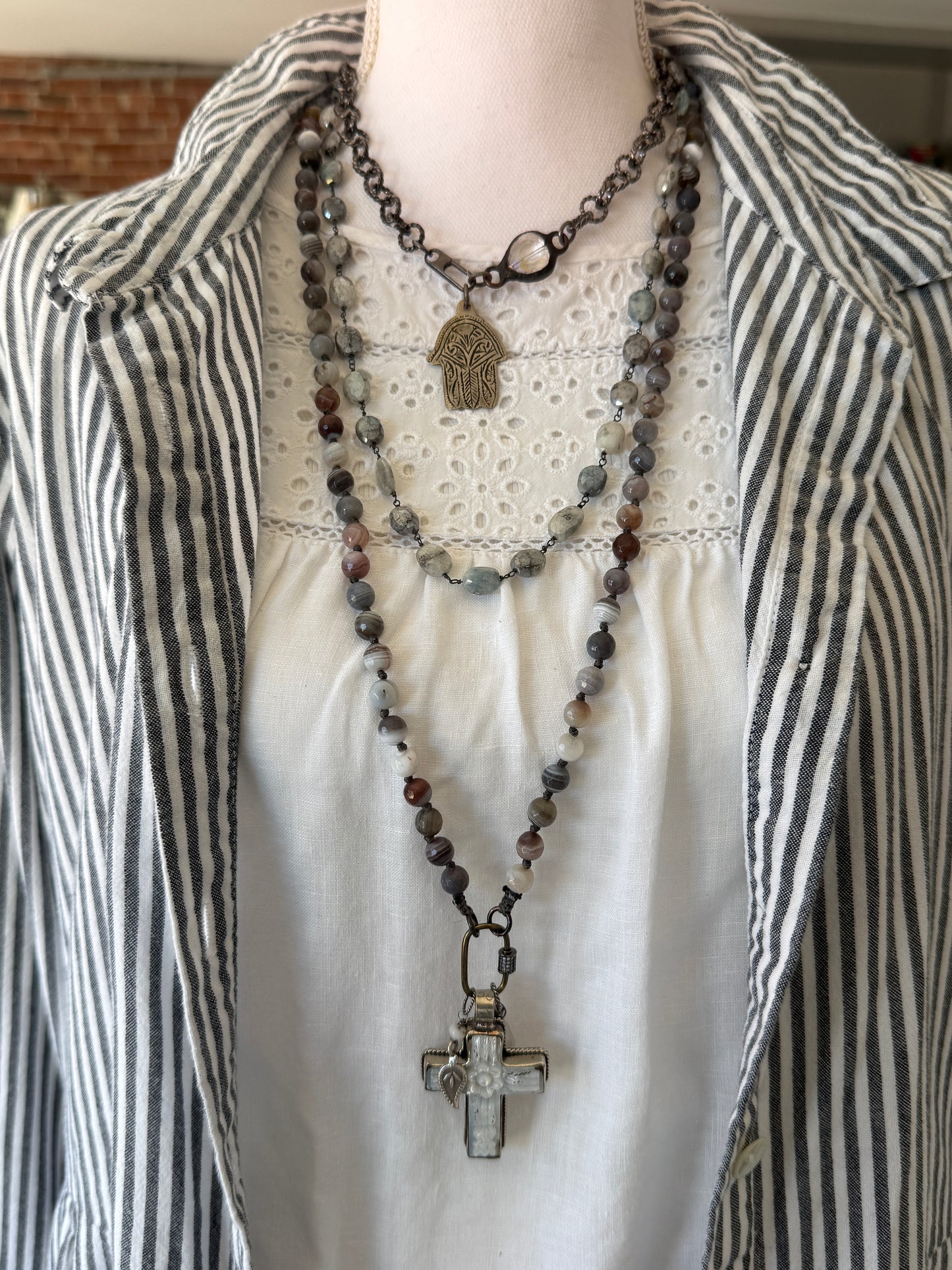 Carved Tibetan Mother of Pearl cross on knotted, faceted Botswana agates necklace.