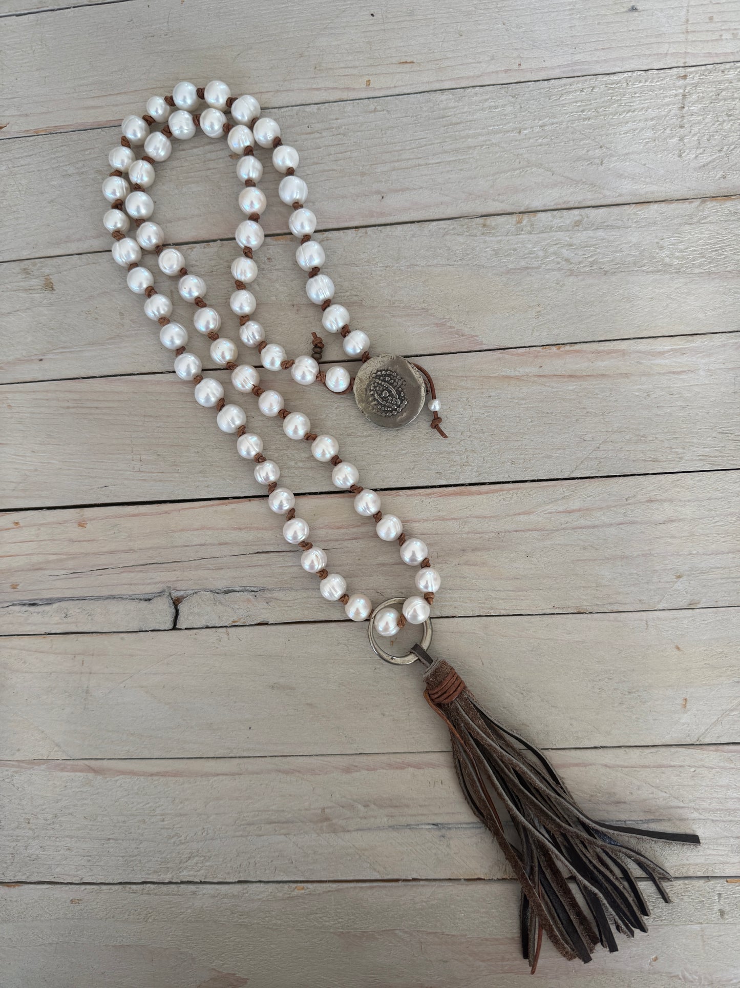 White pearls knotted on leather long necklace with removable tassel.