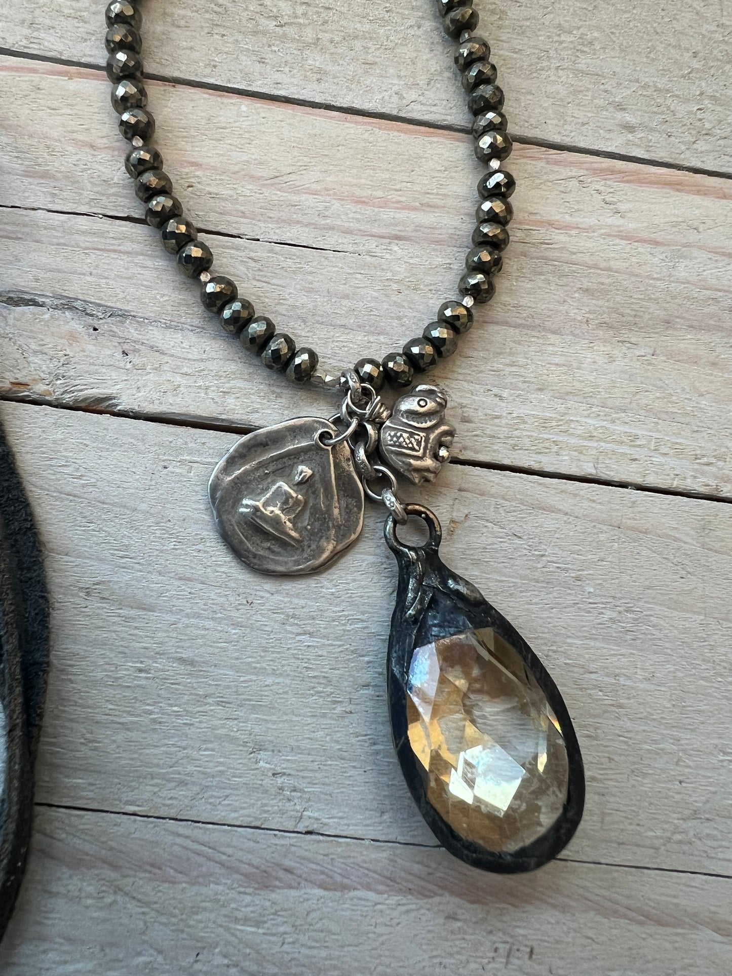 Crystal teardrop with fine silver elephant and sterling sitting buddha and heart pendant on pyrite adjustable necklace.