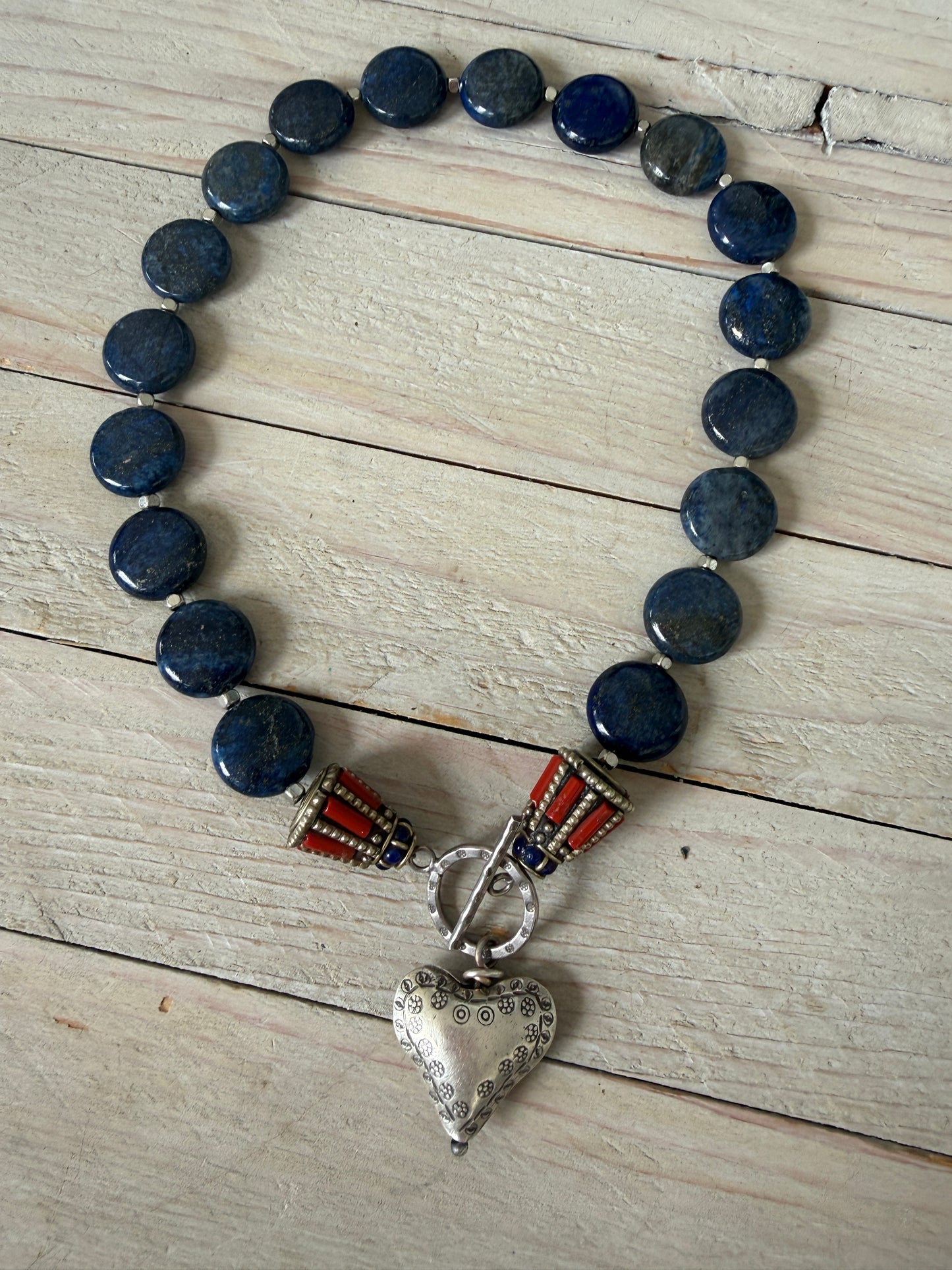 Lapis lazuli coins with Tibetan lapis and coral inlay focal beads necklace. Fine silver toggle clasp and heart. 18”