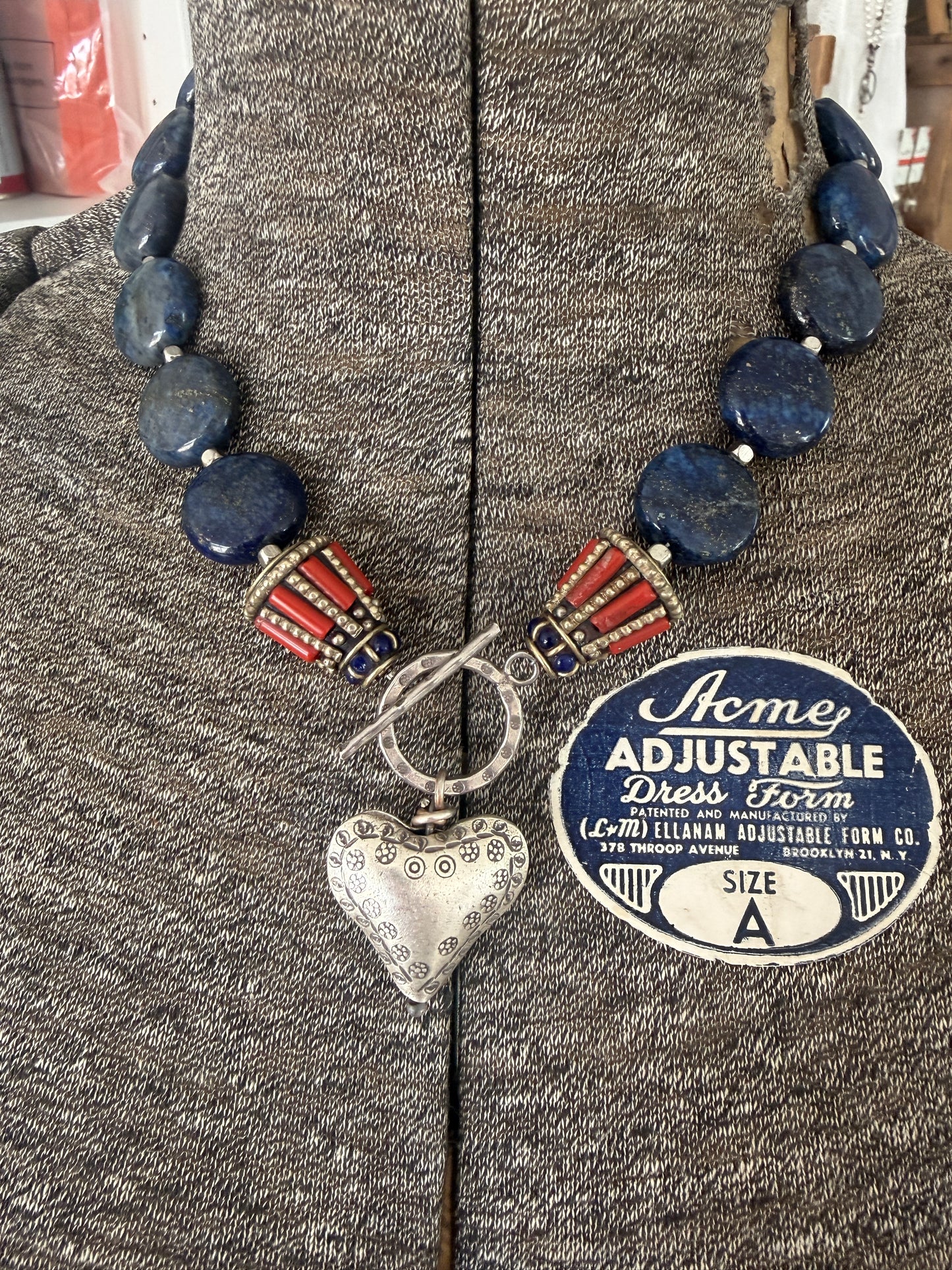 Lapis lazuli coins with Tibetan lapis and coral inlay focal beads necklace. Fine silver toggle clasp and heart. 18”
