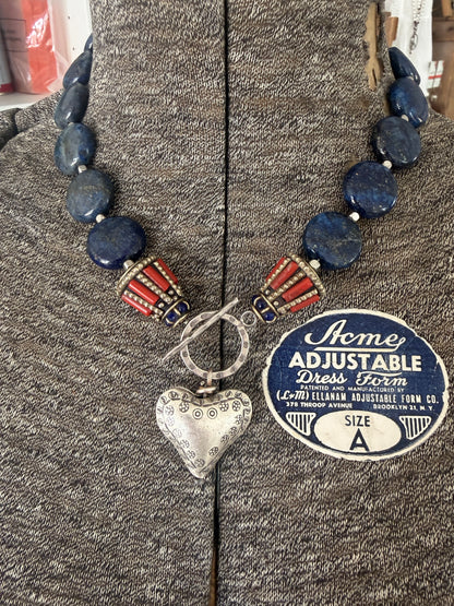 Lapis lazuli coins with Tibetan lapis and coral inlay focal beads necklace. Fine silver toggle clasp and heart. 18”
