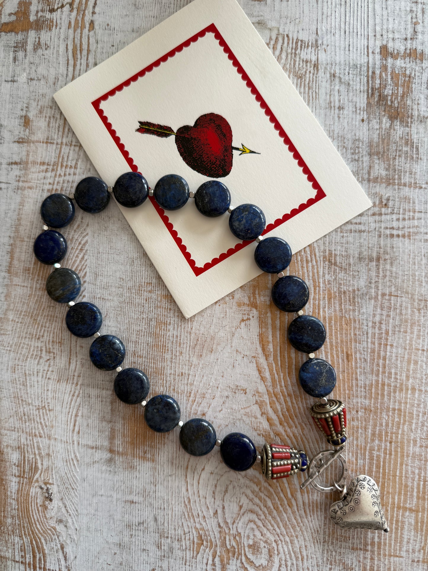 Lapis lazuli coins with Tibetan lapis and coral inlay focal beads necklace. Fine silver toggle clasp and heart. 18”