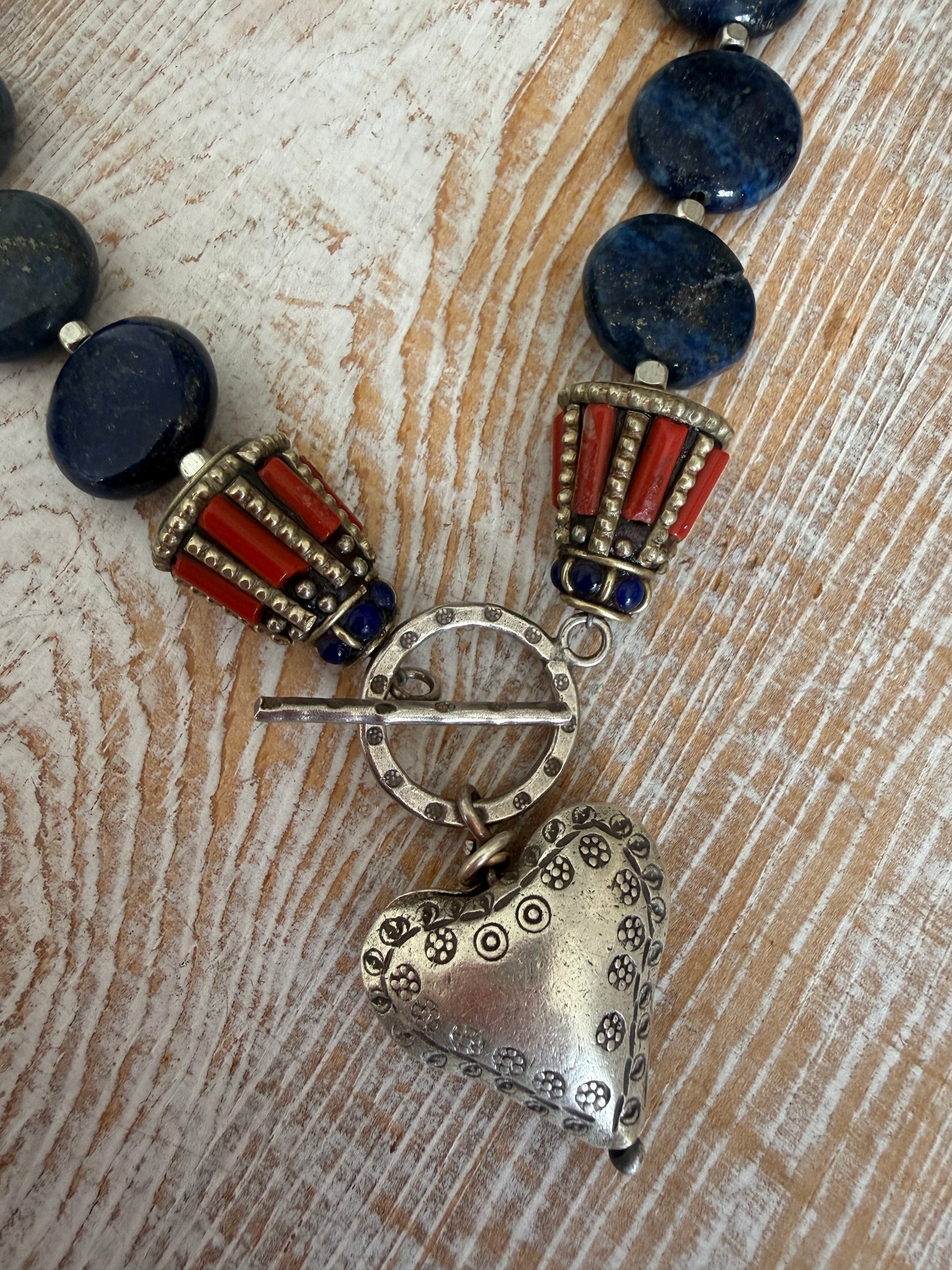 Lapis lazuli coins with Tibetan lapis and coral inlay focal beads necklace. Fine silver toggle clasp and heart. 18”