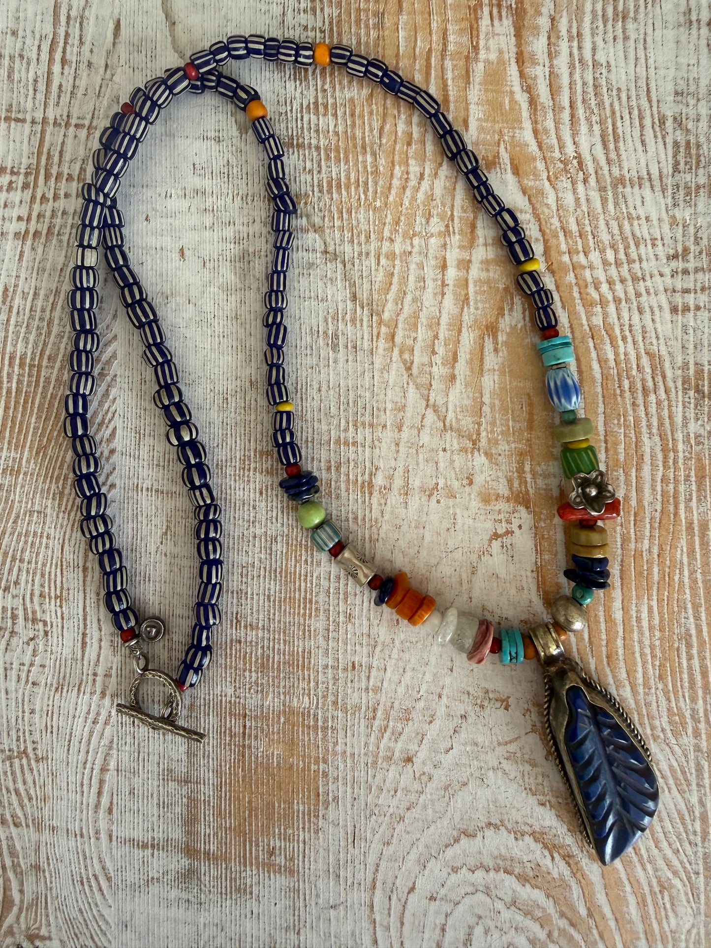 Carved lapis lazuli leaf from Tibet on a mix of gems and trade beads necklace. 25”.