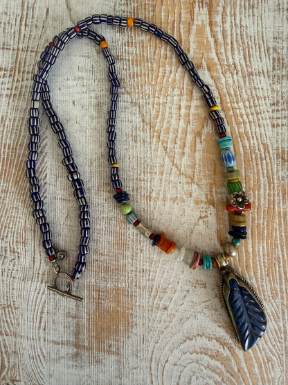 Carved lapis lazuli leaf from Tibet on a mix of gems and trade beads necklace. 25”.