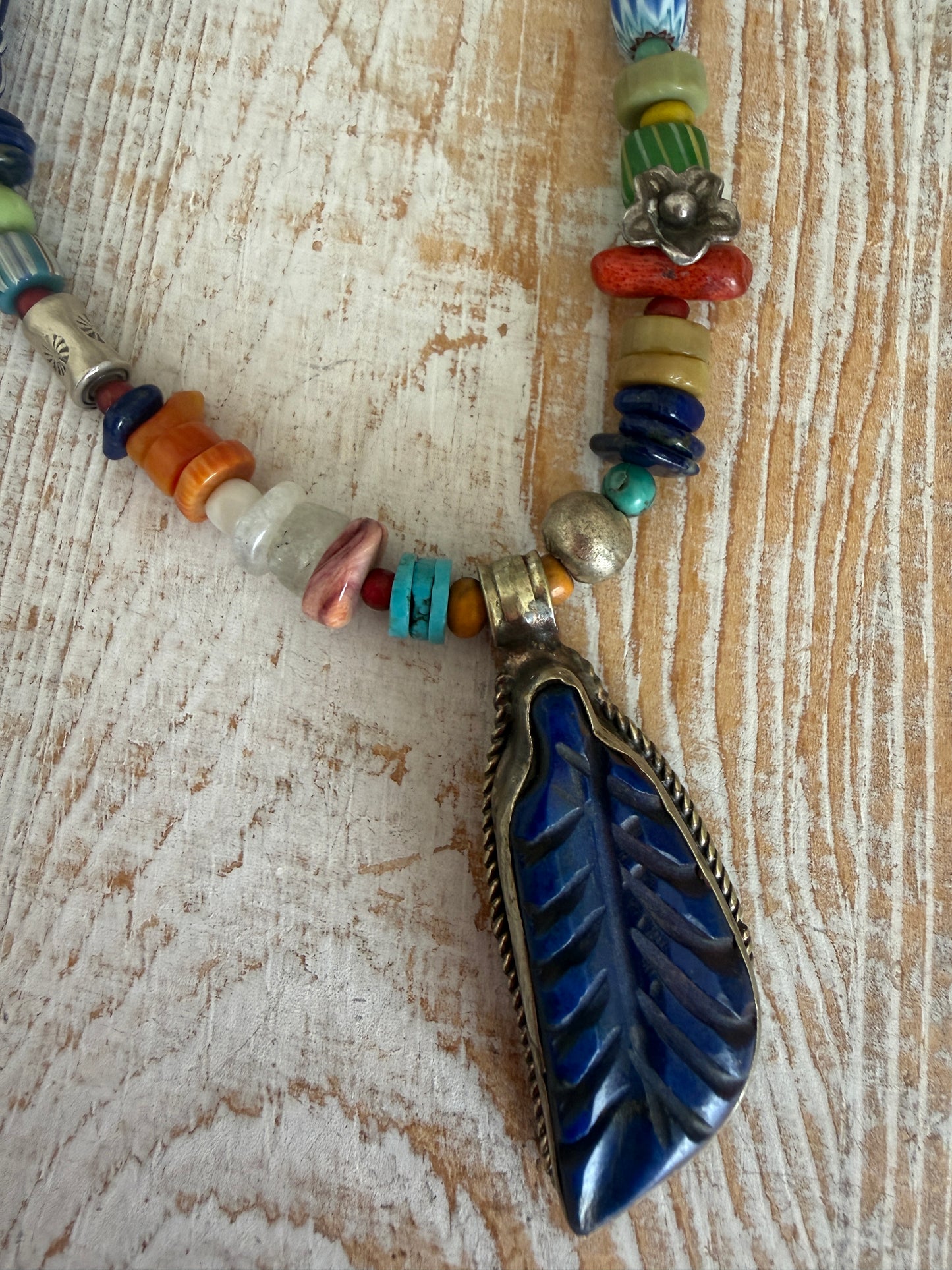 Carved lapis lazuli leaf from Tibet on a mix of gems and trade beads necklace. 25”.