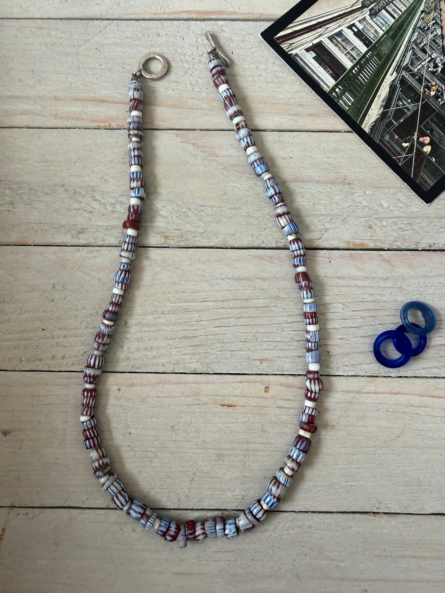 Blue and terracotta red trade bead boho beach necklace with three glass rings. 17.5”