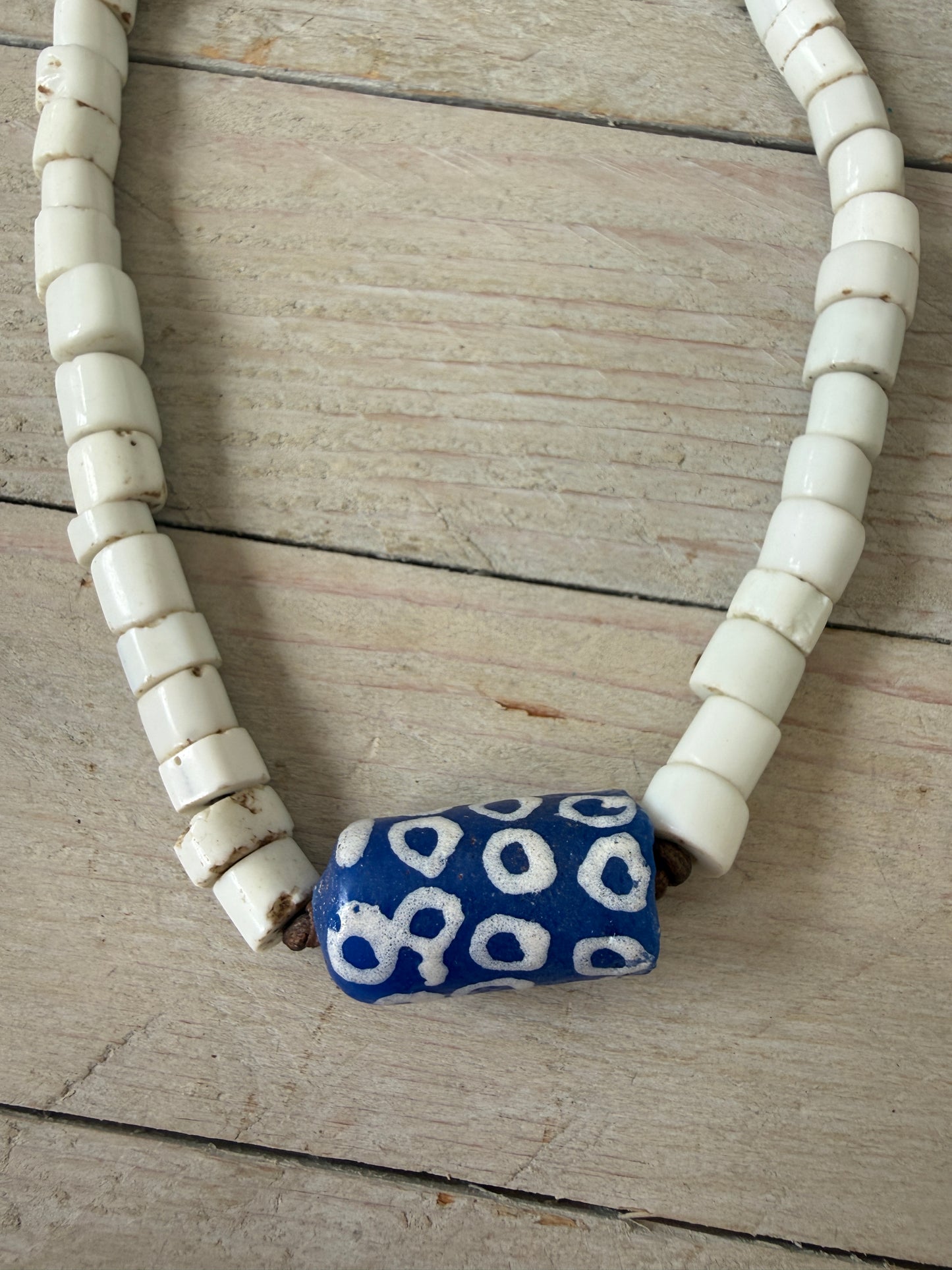 White milk glass beads from Africa with blue polkadot krobo bead focal adjustable necklace on leather. Adjust up to 30”