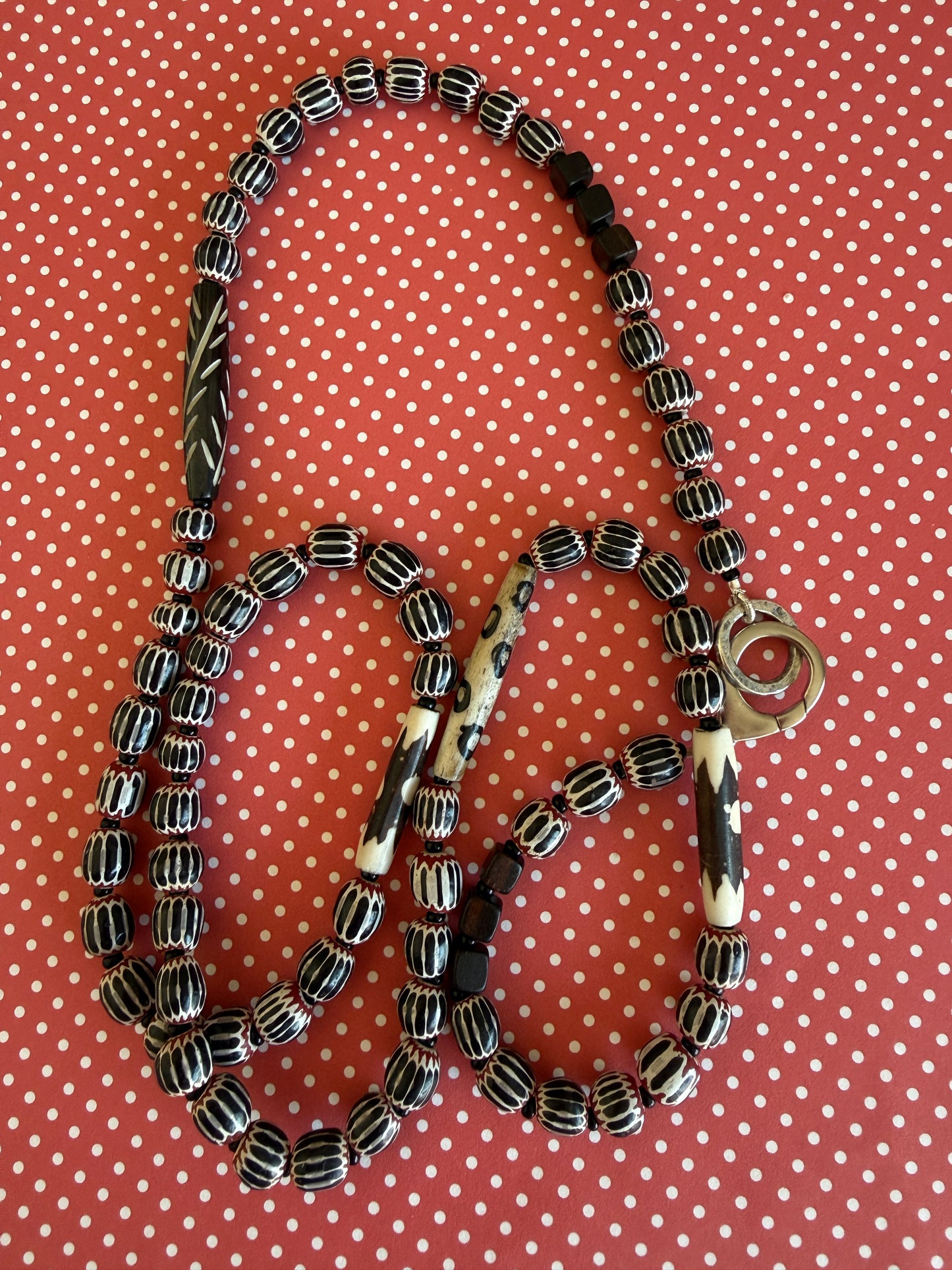 Obsidian beetle pendant on black, red, and white chevron beads with bone accent beads long necklace. Front lobster clasp. 34”