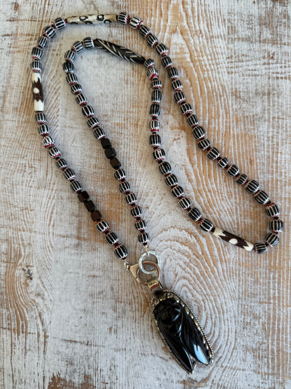 Obsidian beetle pendant on black, red, and white chevron beads with bone accent beads long necklace. Front lobster clasp. 34”