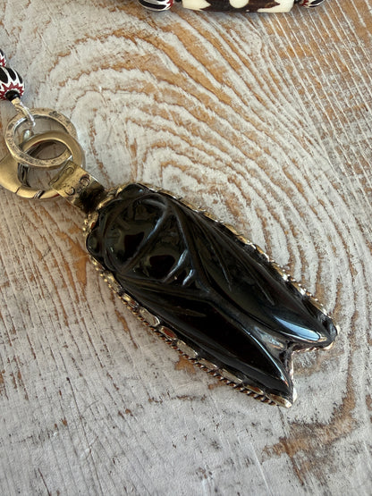 Obsidian beetle pendant on black, red, and white chevron beads with bone accent beads long necklace. Front lobster clasp. 34”