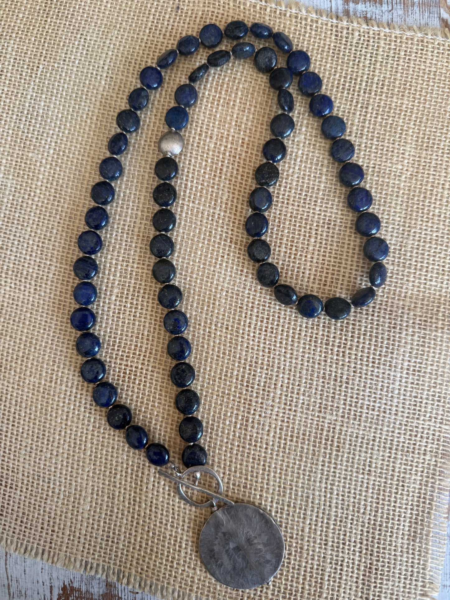 Blue lapis lazuli coins with fine silver front toggle and large textured coin pendant necklace.