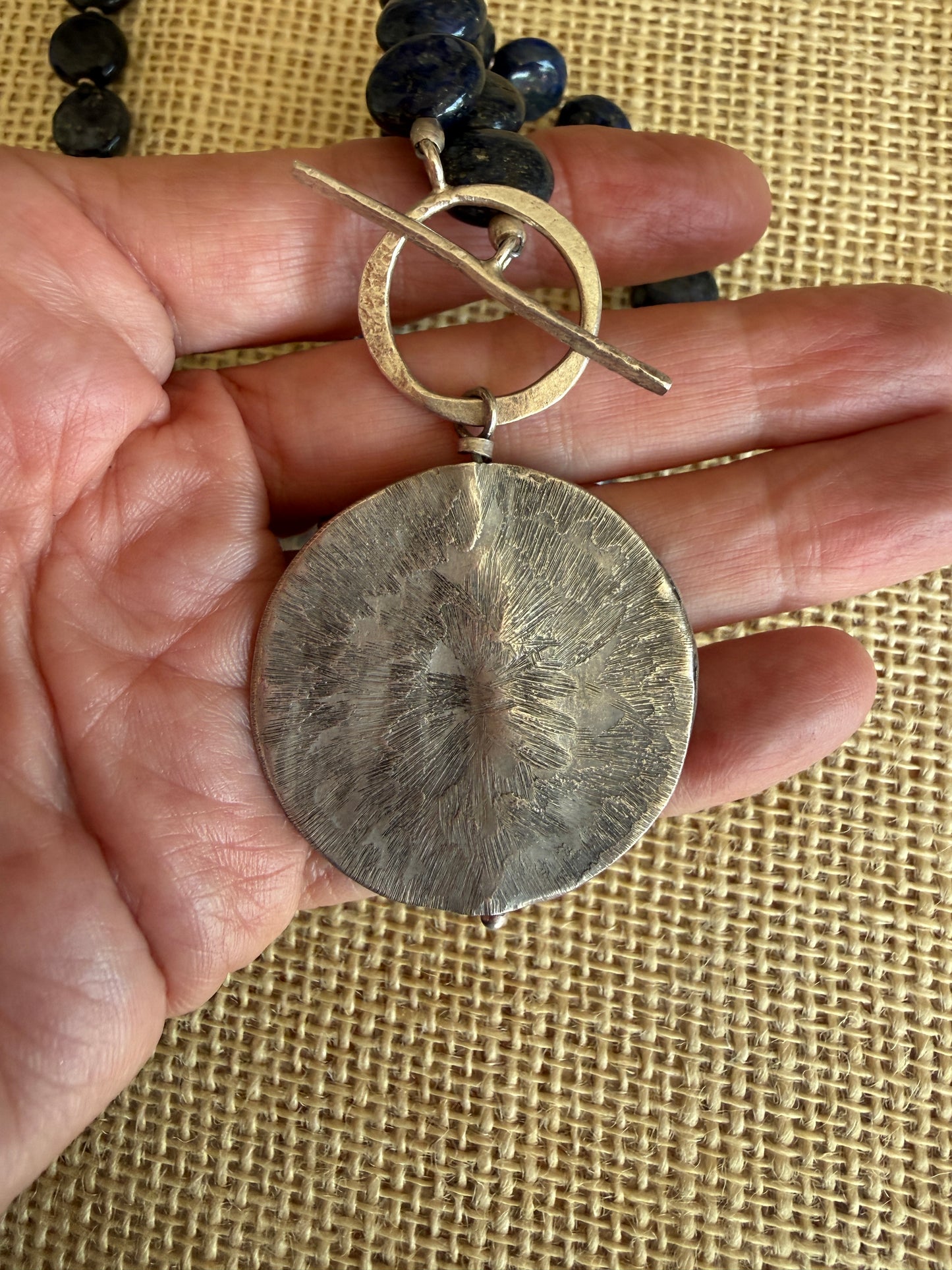 Blue lapis lazuli coins with fine silver front toggle and large textured coin pendant necklace.