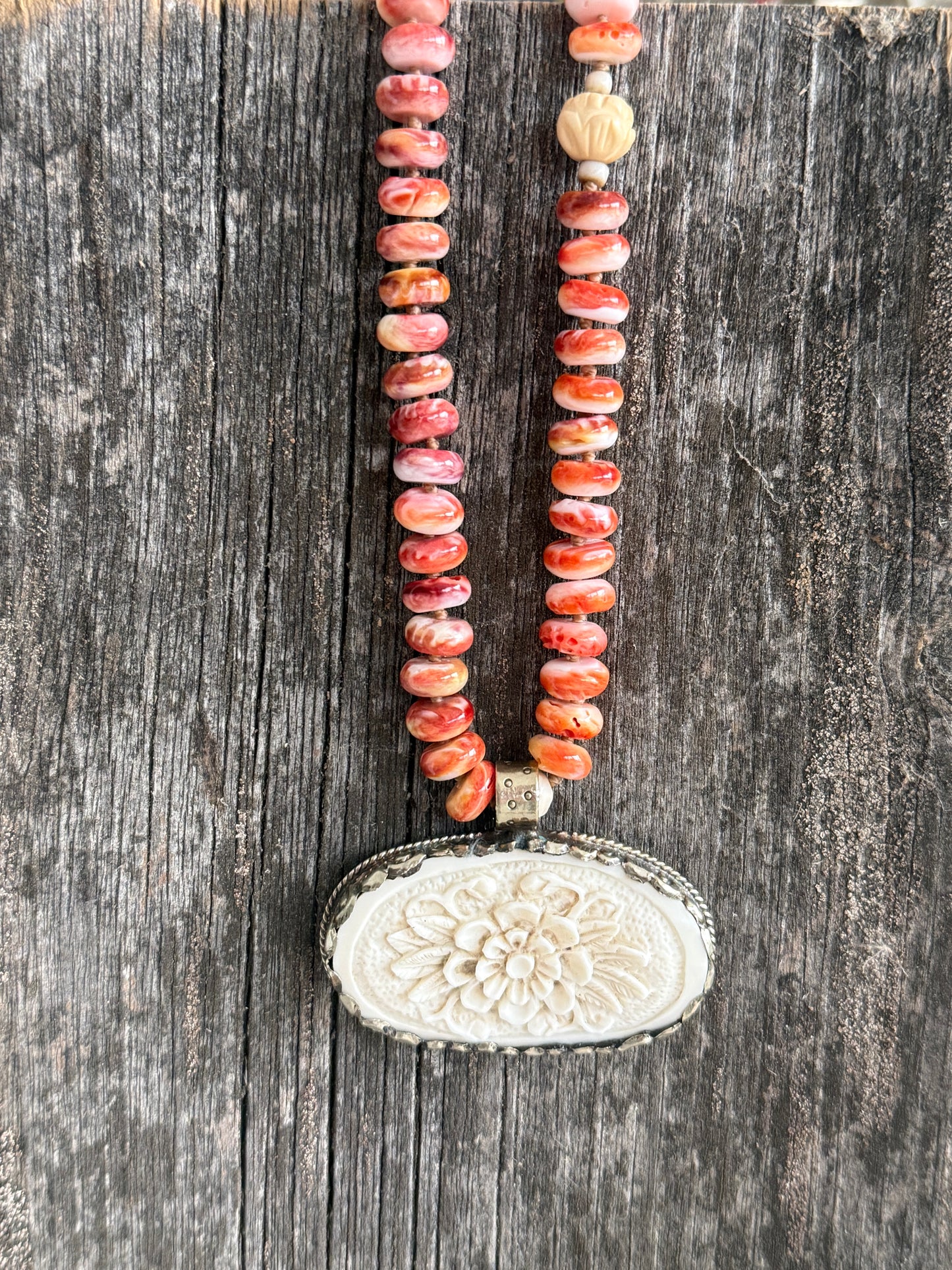 Tibetan carved bone flower pendant on spiny oyster necklace. 16-19”