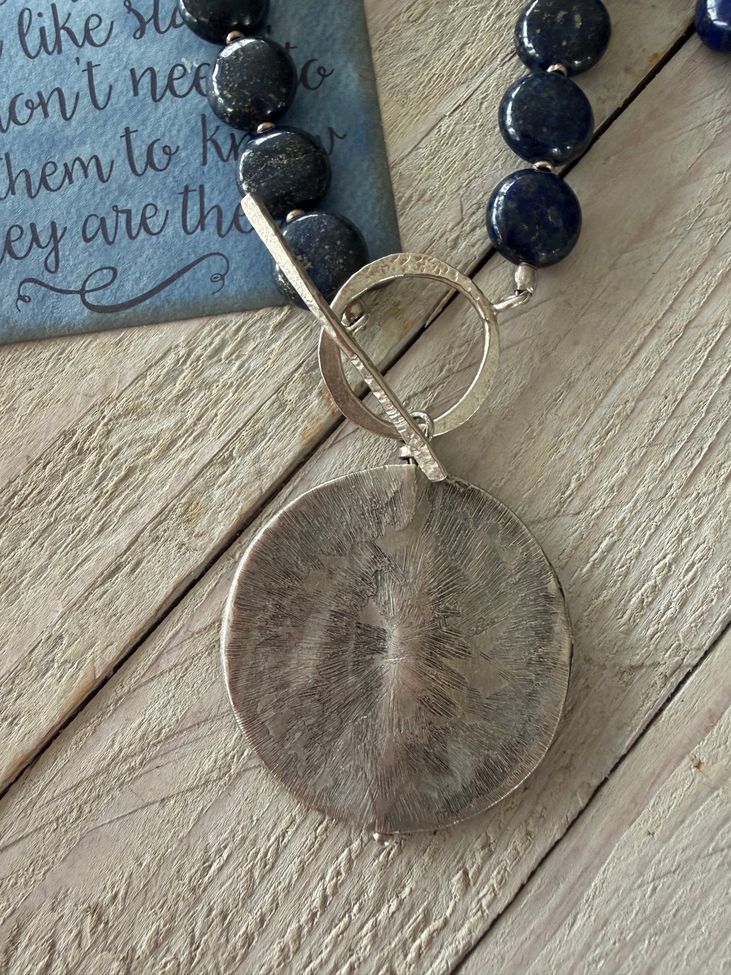 Blue lapis lazuli coins with fine silver front toggle and large textured coin pendant necklace.