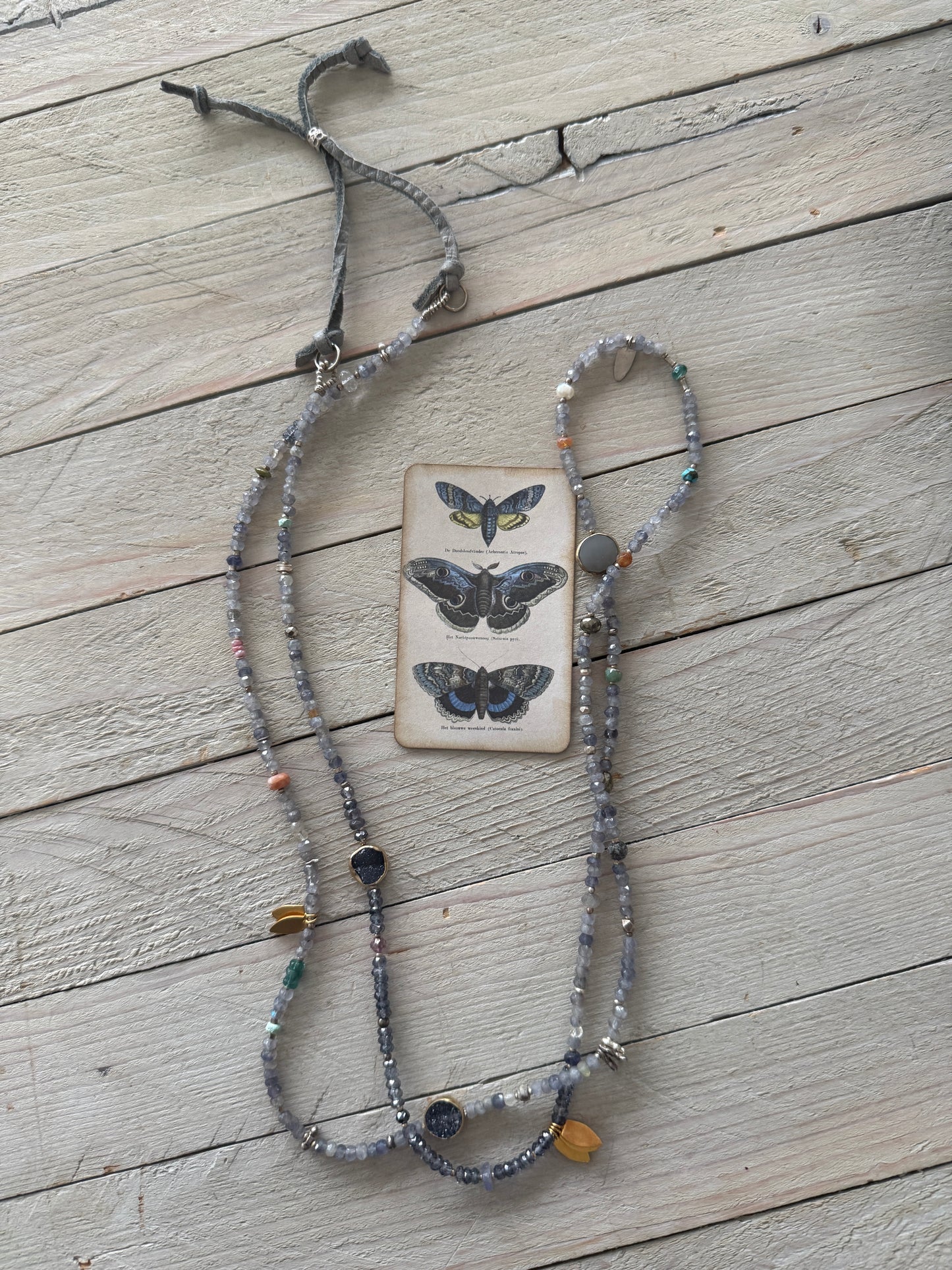Extra long layering necklace/bracelet of pale iolite and assorted gems with vermeil and fine silver accents on adjustable deerskin leather. 50”