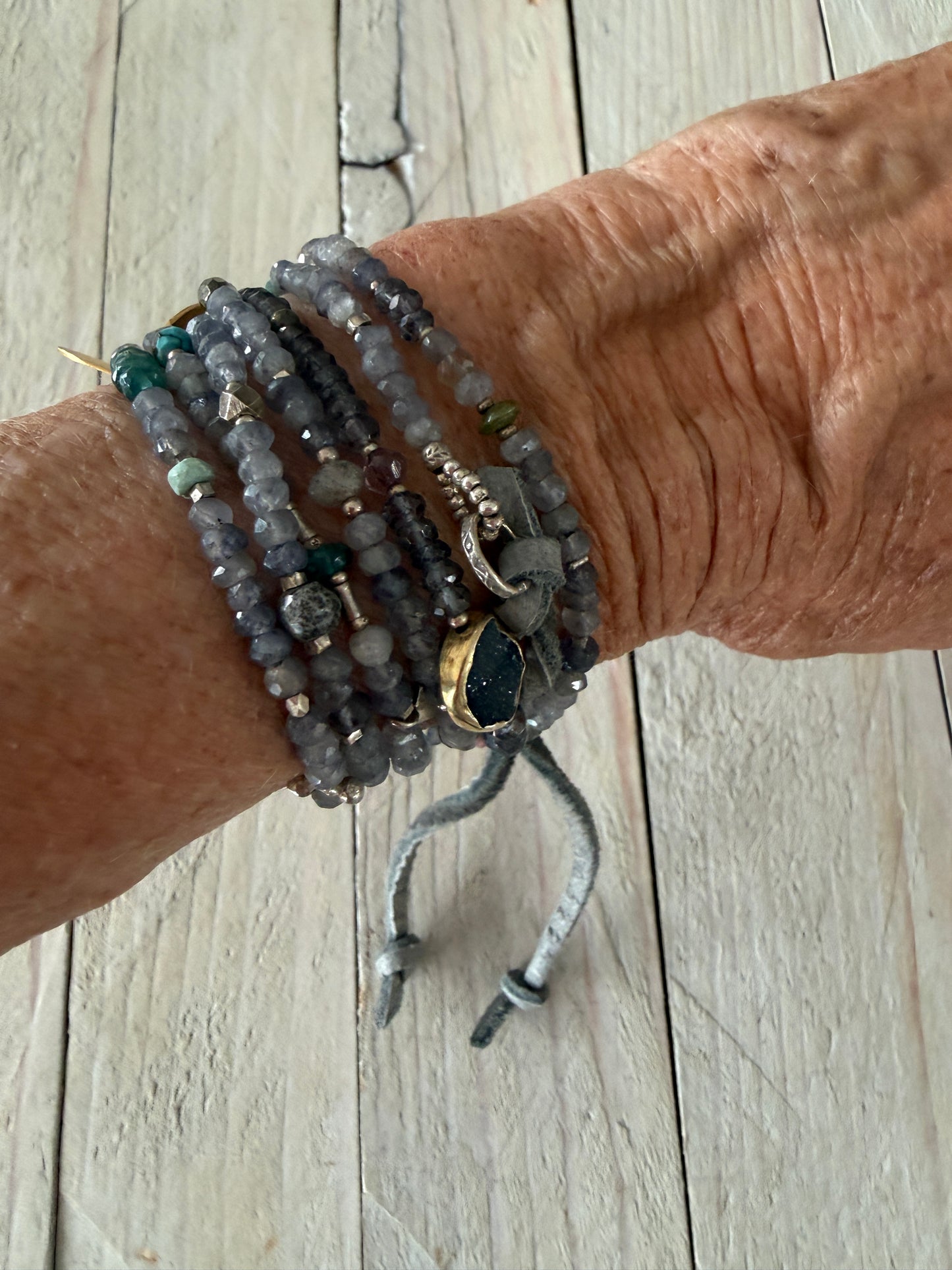 Extra long layering necklace/bracelet of pale iolite and assorted gems with vermeil and fine silver accents on adjustable deerskin leather. 50”