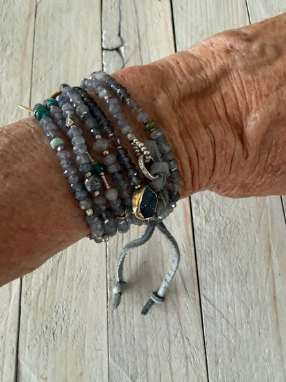 Extra long layering necklace/bracelet of pale iolite and assorted gems with vermeil and fine silver accents on adjustable deerskin leather. 50”