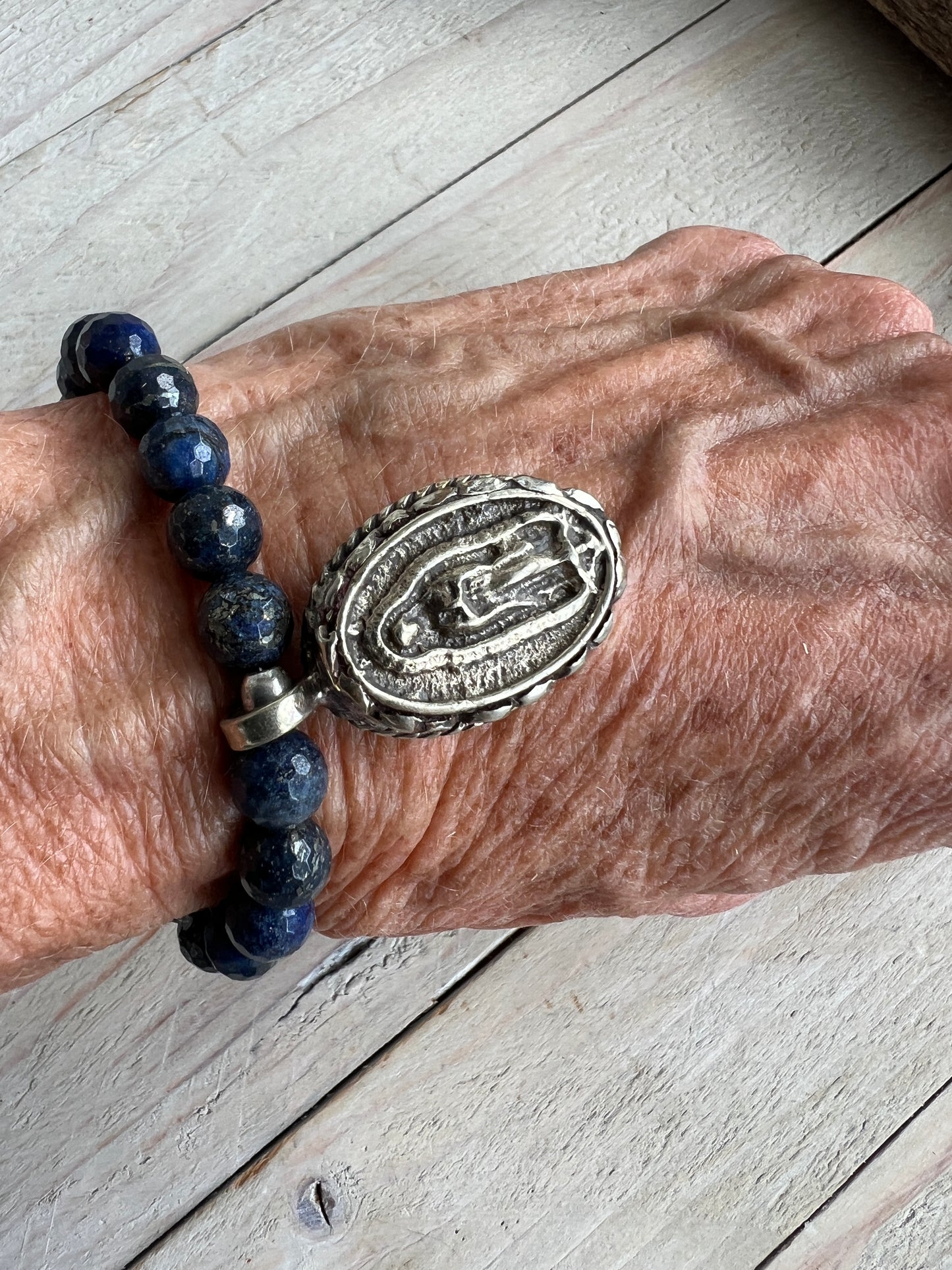 Faceted lapis beads surround a beautiful Tibetan repousé Mary. Stretch stacker bracelet 6-6.5”