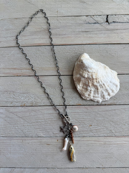 Oxidized sterling chain necklace with front toggle, bumblebee jasper fish, fine silver starfish, white coral, shell, and spiny oyster danglies.