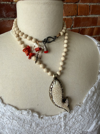 Tibetan carved bone fish on knotted riverstone and coral long necklace. Coral and fine silver fish charms.