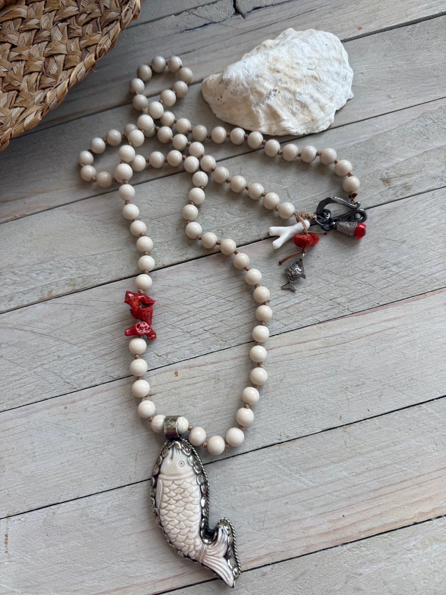 Tibetan carved bone fish on knotted riverstone and coral long necklace. Coral and fine silver fish charms.