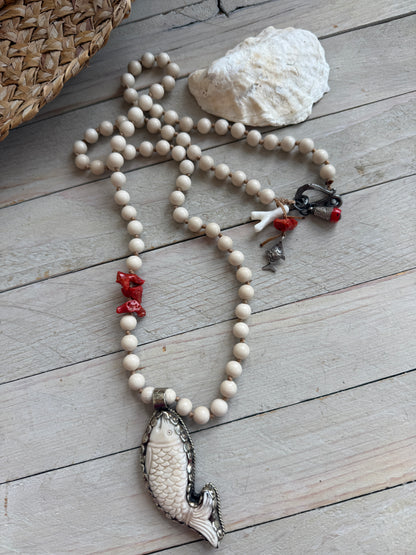 Tibetan carved bone fish on knotted riverstone and coral long necklace. Coral and fine silver fish charms.