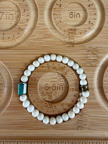 White riverstone stretch stack bracelet with turquoise and bone inlay bead from Nepal. 6.5”