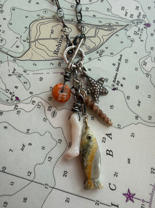 Oxidized sterling chain necklace with front toggle, bumblebee jasper fish, fine silver starfish, white coral, shell, and spiny oyster danglies.
