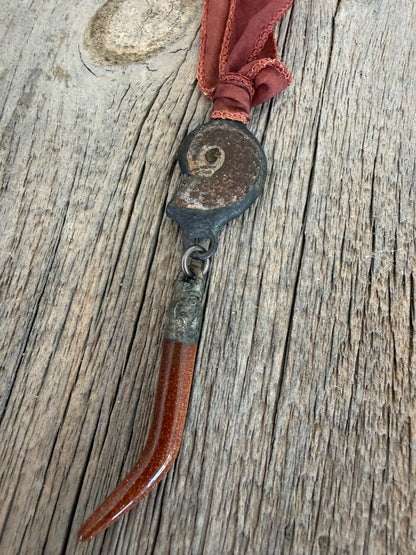 Ammonite and goldstone tusk on rust silk ribbon necklace. Adjustable to 36”