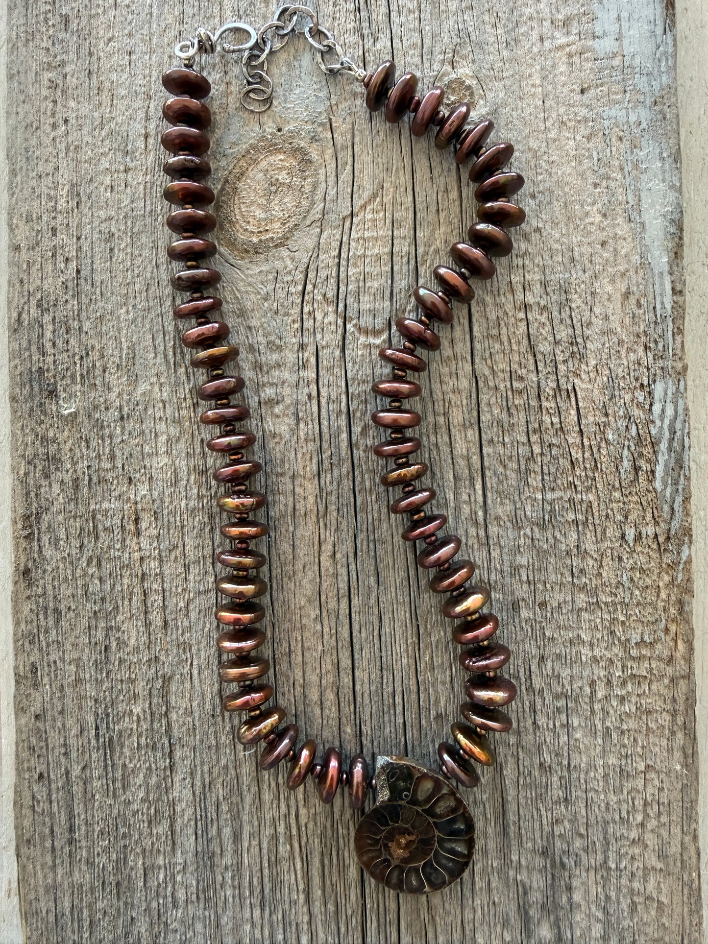 A natural ammonite fossil and chocolate brown button pearl necklace.