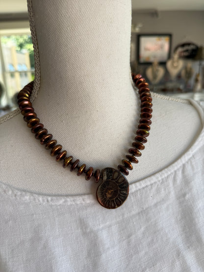 A natural ammonite fossil and chocolate brown button pearl necklace.