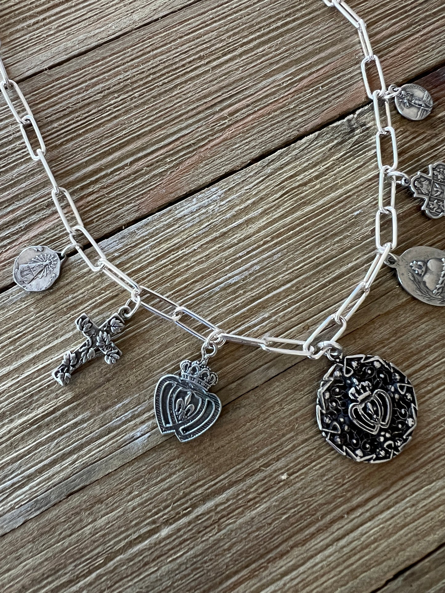 Aged sterling silver heart, cross, and saints medals on paperclip chain, sterling silver necklace. Adjustable to 18.5”.