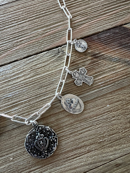 Aged sterling silver heart, cross, and saints medals on paperclip chain, sterling silver necklace. Adjustable to 18.5”.