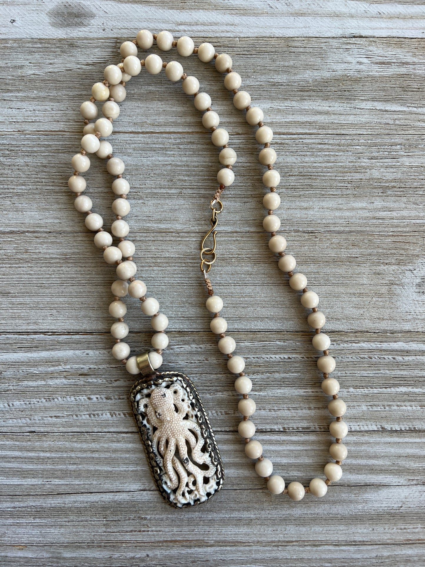 Exquisite carved bone octopus on hand-knotted matte riverstone beads..  39” necklace. Wear long or short.