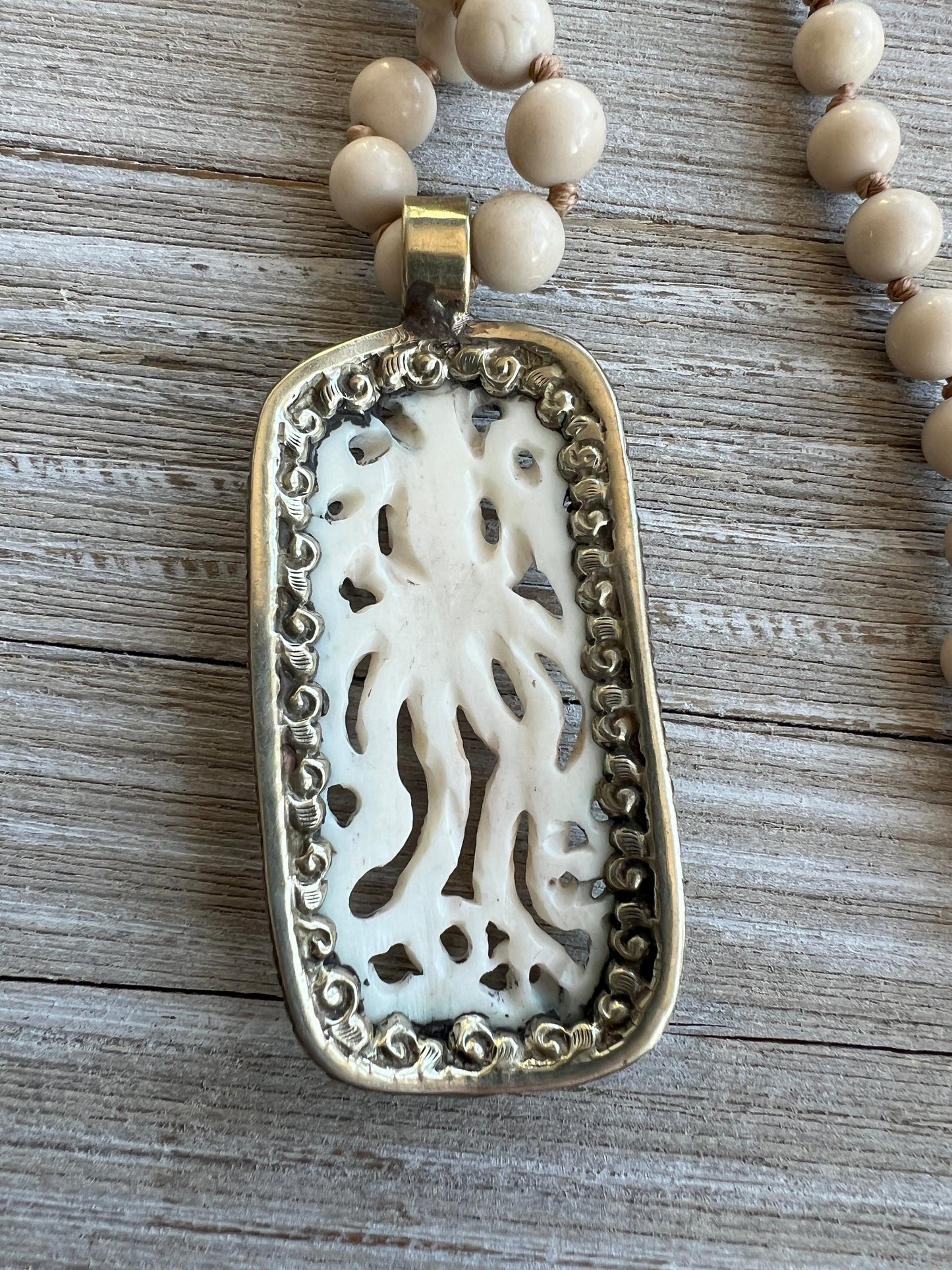 Exquisite carved bone octopus on hand-knotted matte riverstone beads..  39” necklace. Wear long or short.