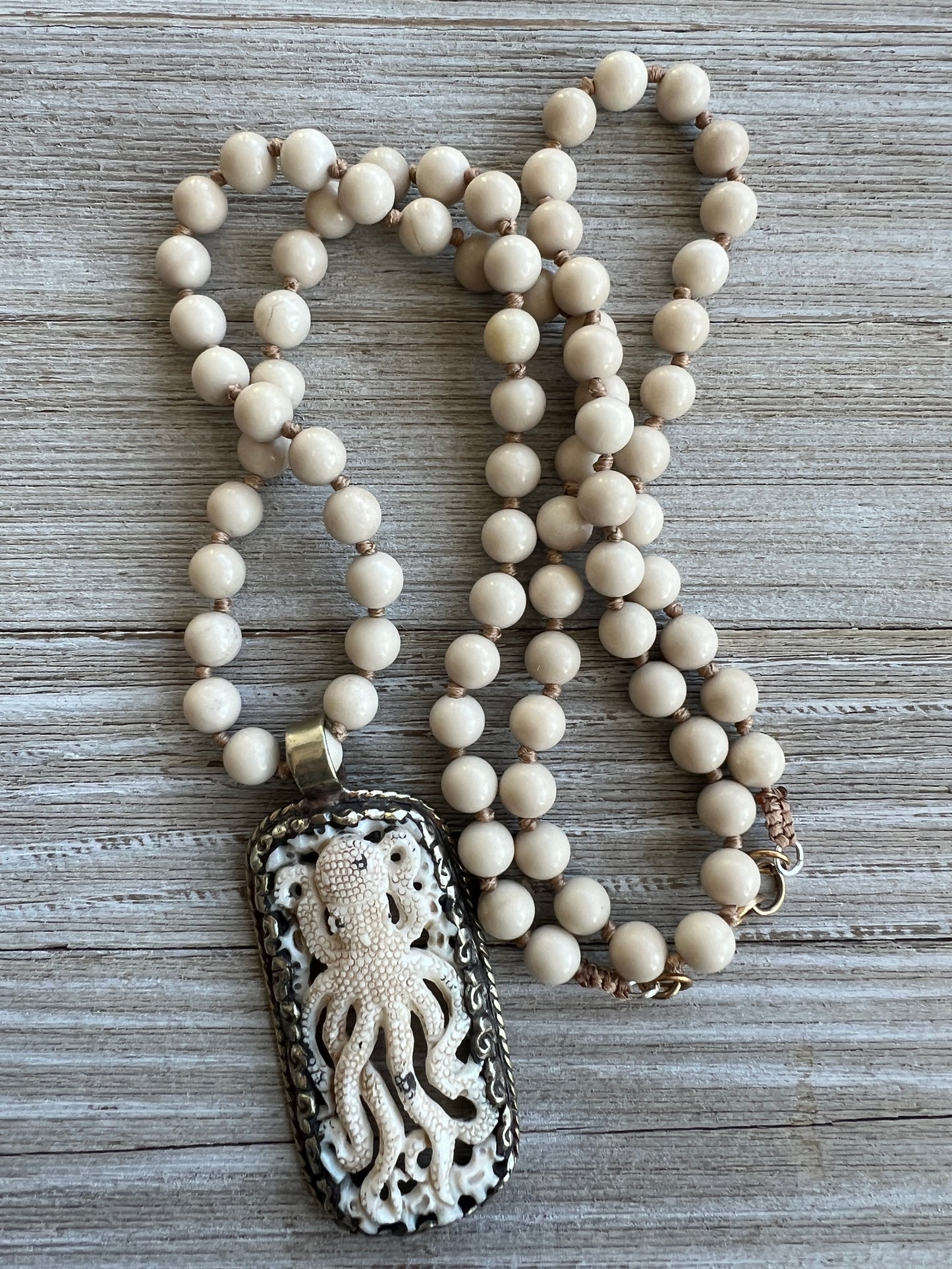 Exquisite carved bone octopus on hand-knotted matte riverstone beads..  39” necklace. Wear long or short.